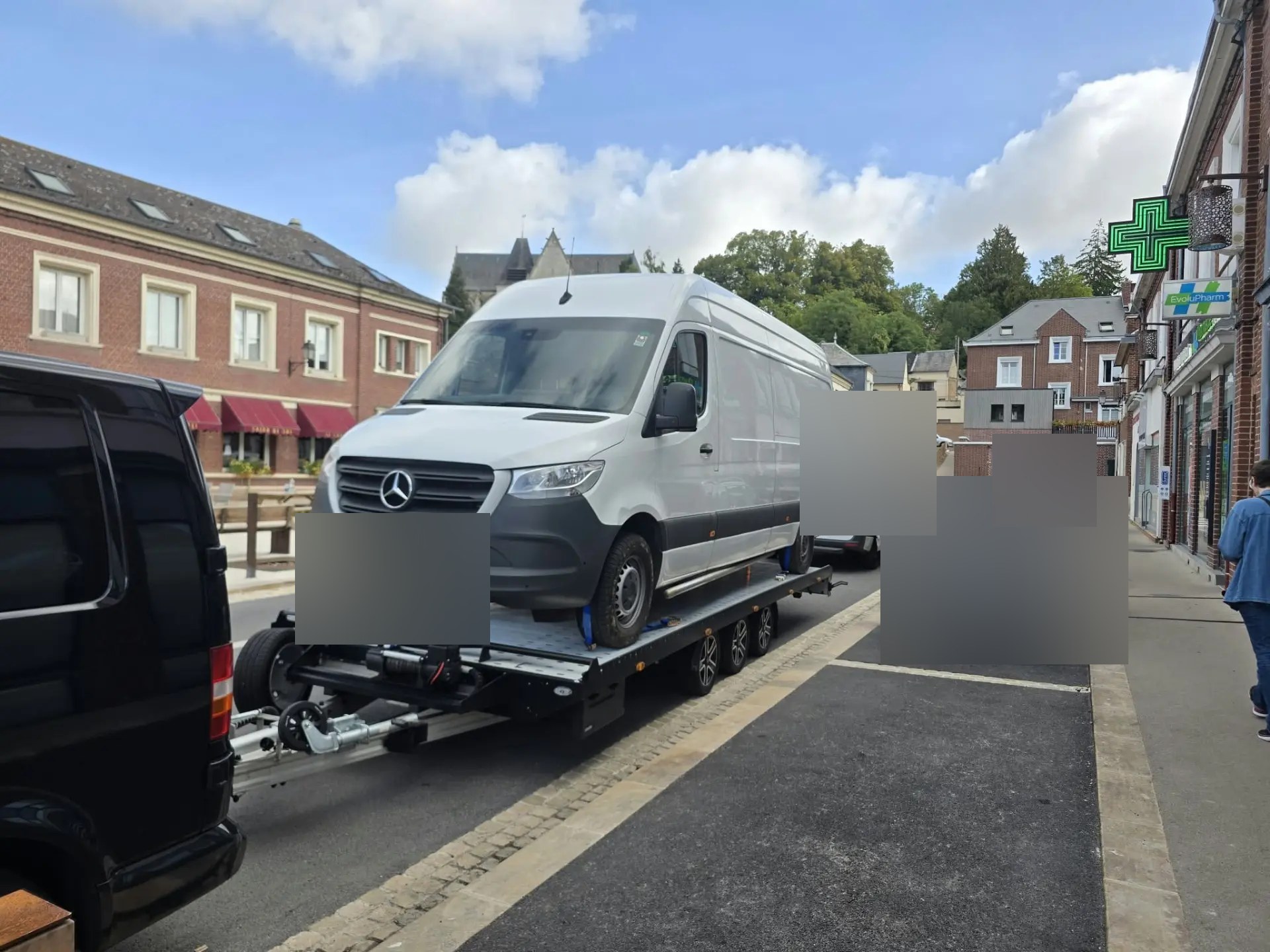 Bestelbus op een autotrailer langs de weg